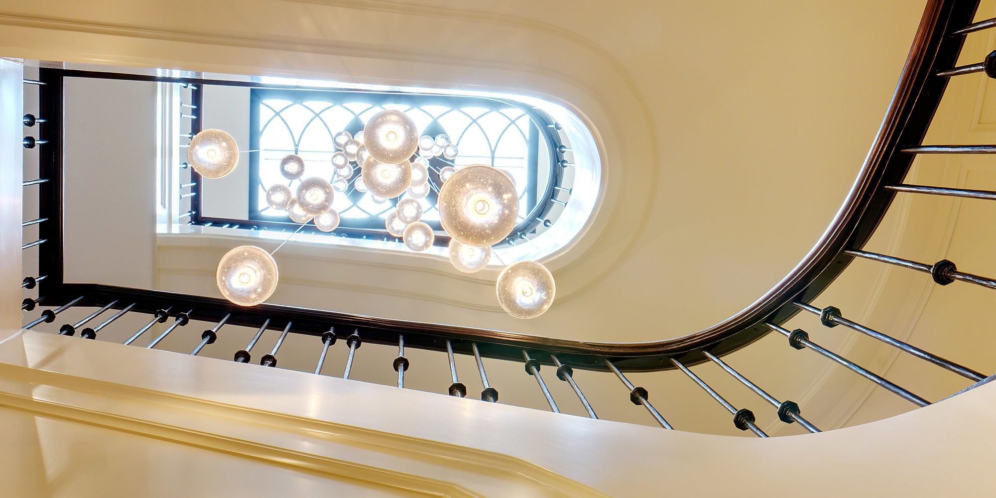 Circular Crystal Pendant Lights hang beautifully in bright and airy spiral staircase.