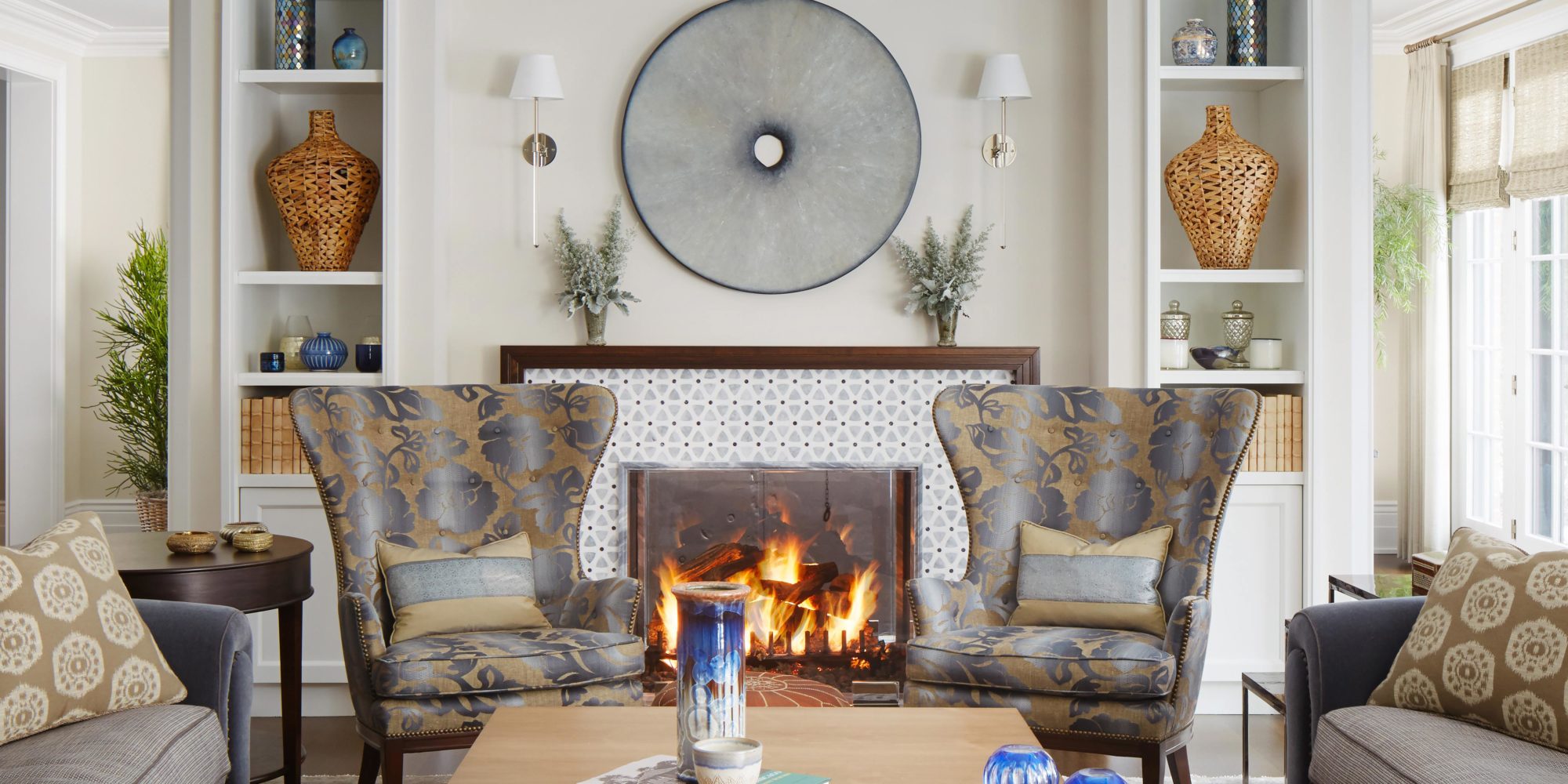 Bright and airy Living Room designed by Soucie Horner incorporates Fanback Wingchair from Edward Ferrel and Lewis Mittman using Anthony Inc Upholstery, William H Jackson Company Firescreen, and Wall-mount sconce from Urban Electric