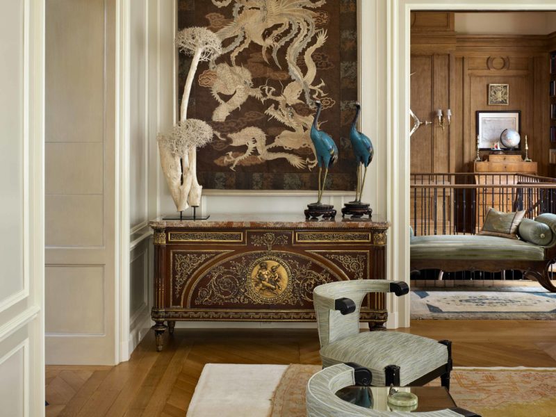 Beautiful Living Room designed by Soucie Horner incorporates Antique Credenza, Antique Wall Art, and peacock sculptures.