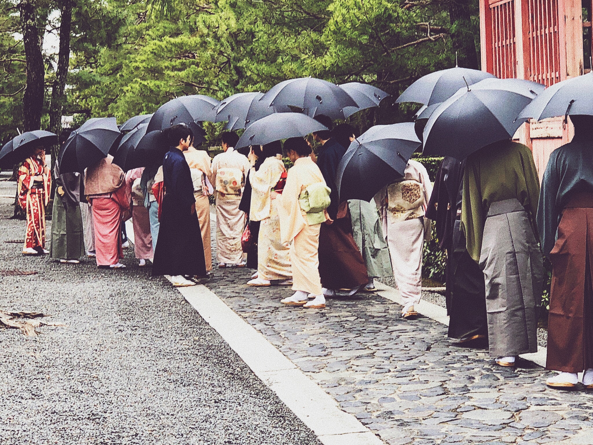 Street filled with geishas with umbrellas