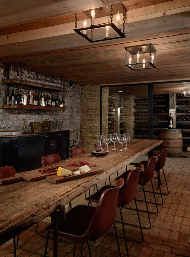 Wine Cellar gives off a Parisian feel through use of wood and brick, candle chandeliers, and long wooden table.