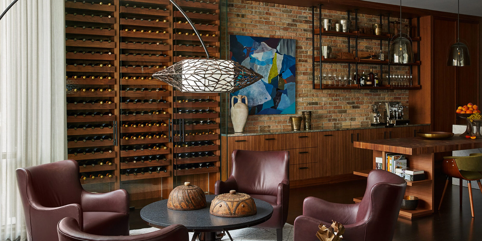 Sitting area incorporates wingback chairs by Lee Industries, Kenneth Cobonpue Arc Floor Lamp, and abstract artwork by Vidvuds Zviedris