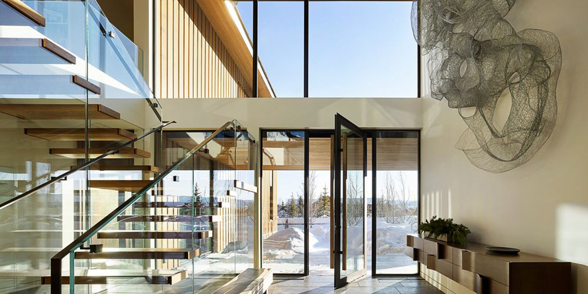 Bright and Airy Foyer Interior Design with Glass Staircase and High Ceiling