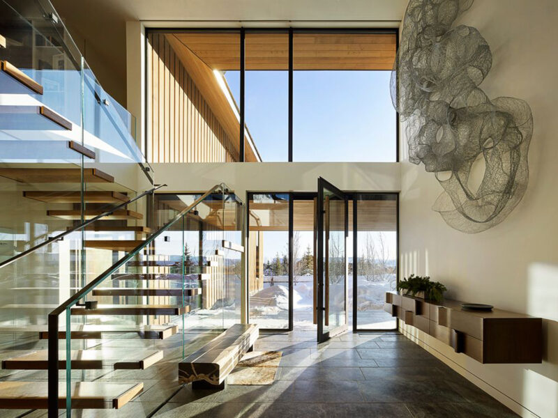 Bright and Airy Foyer Interior Design with Glass Staircase and High Ceiling