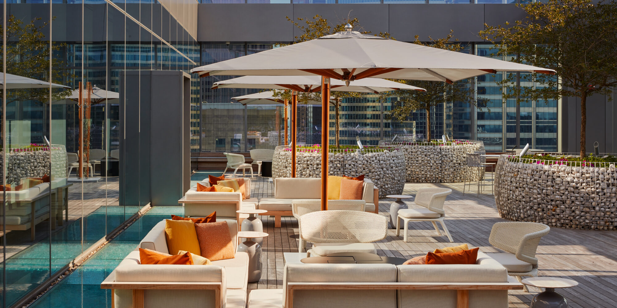 Colorful Outdoor Patio Featuring Orange Pillows and Sitting Areas with Umbrellas