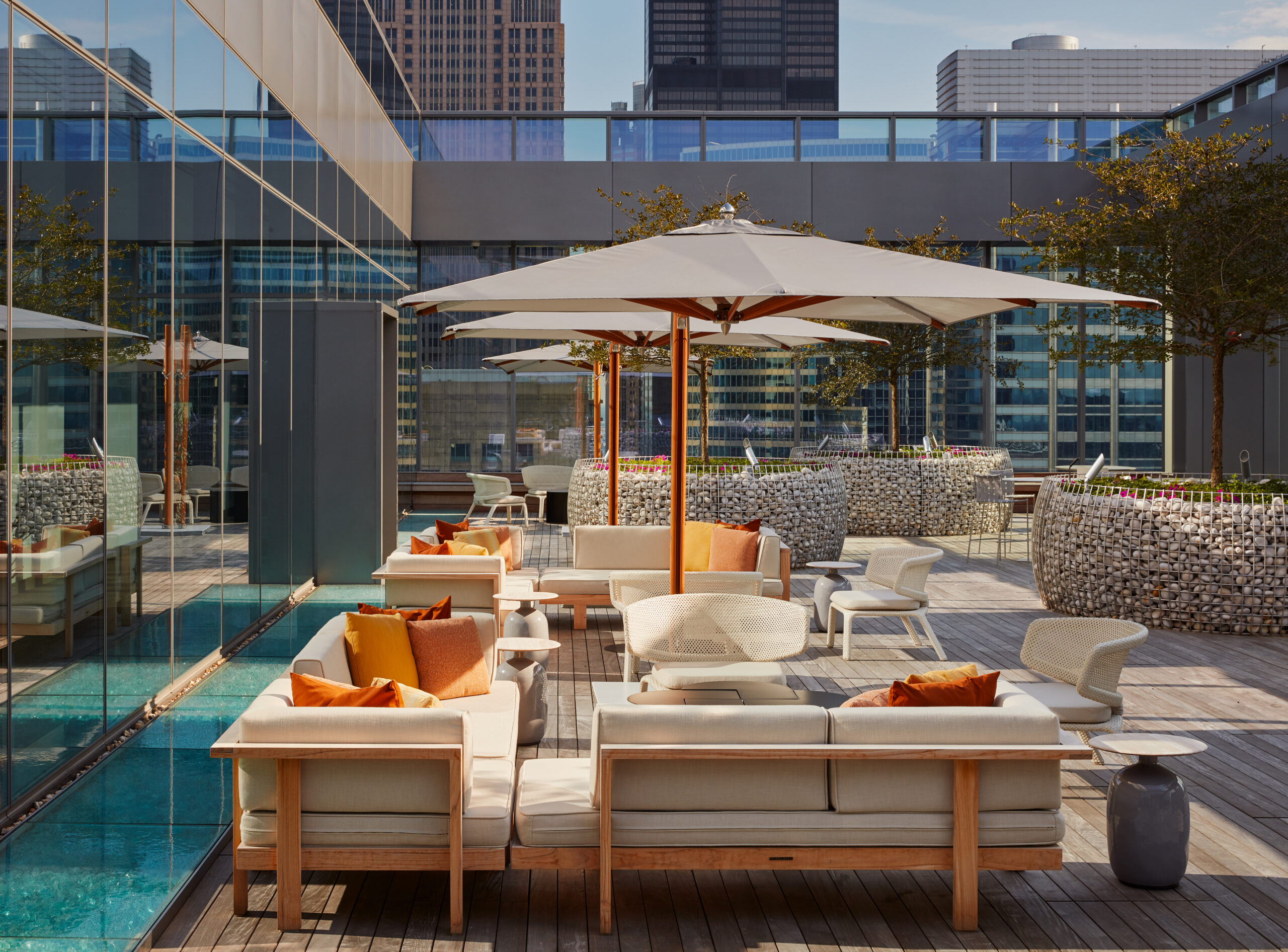 Colorful Outdoor Patio Featuring Orange Pillows and Sitting Areas with Umbrellas