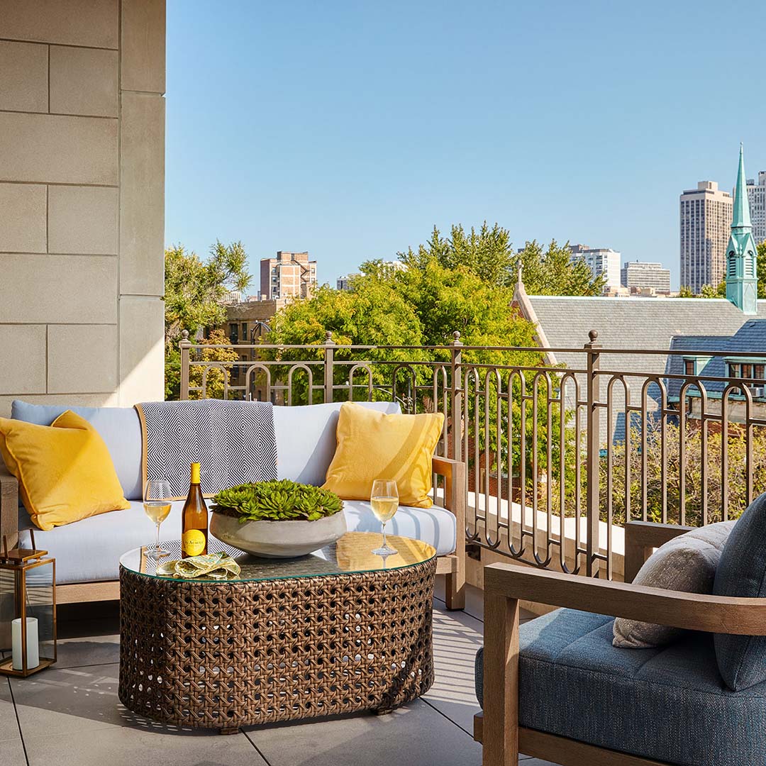 Private Terrace Overlooking the Chicago Skyline with Small Couch, Chair and Yellow Pillows